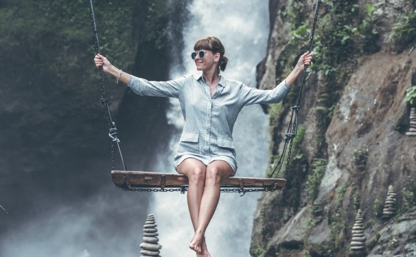 Girl on a swing with a waterfall located behind her to illustrate the balance of hormones in the human body