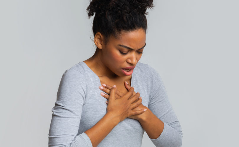 woman holding her chest and suffering from acid reflux